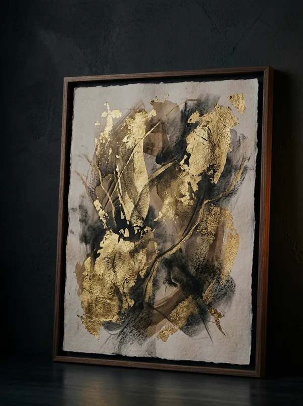 Gold leaf and charcoal abstract artwork in slender dark frame