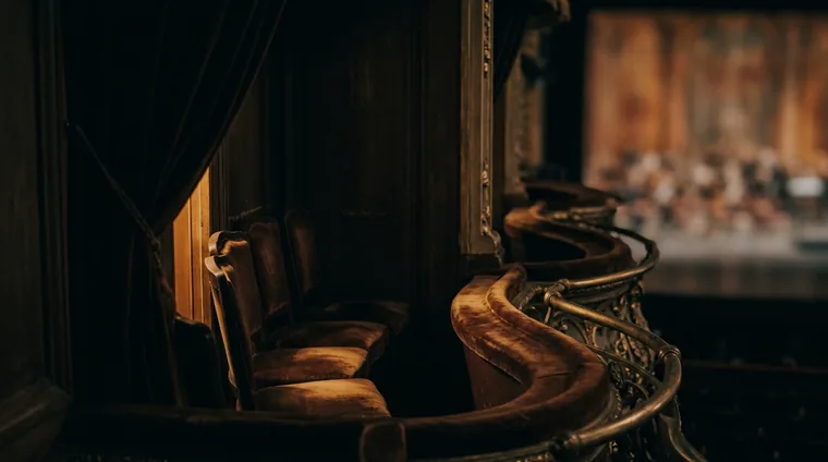Private opera box interior — velvet drapery, gilded railing, stage glow